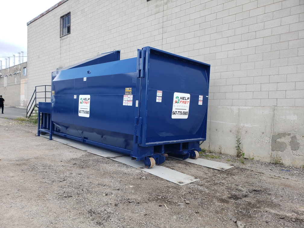Worker at a waste container throwing away folders
